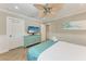 Bedroom showcases a TV, ceiling fan, wood-look tile floors, and white wainscoting at 733 Holly Rd, Anna Maria, FL 34216