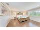 Bright bedroom with a four-poster bed, wood floors, plantation shutters, and coastal decor at 733 Holly Rd, Anna Maria, FL 34216