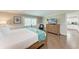 Bright bedroom with a view to the kitchen, featuring a four-poster bed and a wooden dresser at 733 Holly Rd, Anna Maria, FL 34216