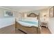 Bedroom with white walls, wood floors, a four-poster bed, and white nightstands at 733 Holly Rd, Anna Maria, FL 34216