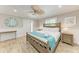 Bedroom with a wooden bed frame, ceiling fan, decorative mirror, and wood-look tile flooring at 733 Holly Rd, Anna Maria, FL 34216