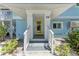 Close-up of the bright yellow front door and the stairs leading up to the entrance at 733 Holly Rd, Anna Maria, FL 34216