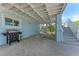 Exterior view of home showing lower level with grill, stairs and under house parking at 733 Holly Rd, Anna Maria, FL 34216