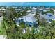 A beautiful, light blue, well-maintained home surrounded by lush tropical greenery and mature trees at 733 Holly Rd, Anna Maria, FL 34216