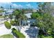 Beautiful coastal home with a light blue exterior, lush landscaping, and a pristine white driveway at 733 Holly Rd, Anna Maria, FL 34216