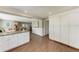 Open kitchen with wood floors, granite counters, and ample storage in white cabinets at 733 Holly Rd, Anna Maria, FL 34216