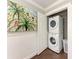 Efficient laundry area with stacked washer and dryer and artistic painting at 733 Holly Rd, Anna Maria, FL 34216