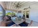 Covered outdoor patio with ample seating, a dining table, and a mounted television at 733 Holly Rd, Anna Maria, FL 34216