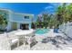 Backyard pool area with outdoor seating, lush landscaping, and blue skies offers a private oasis at 733 Holly Rd, Anna Maria, FL 34216
