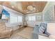 Bright sitting room with wood ceiling, ceiling fan, comfortable seating, and shuttered windows at 733 Holly Rd, Anna Maria, FL 34216
