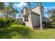 A view of the backyard with a green lawn and a screened in patio surrounded by lush trees at 7615 Charleston St, Bradenton, FL 34201