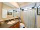 Well-lit bathroom featuring a sink, toilet, shower, and large mirror at 7615 Charleston St, Bradenton, FL 34201