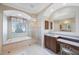 Bright bathroom featuring a soaking tub, walk-in shower, and double sink vanity at 7615 Charleston St, Bradenton, FL 34201