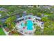 Aerial view of the community pool and amenity center, with lush landscaping and ample parking at 7615 Charleston St, Bradenton, FL 34201