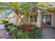 Close-up of the home's entrance, showcasing elegant columns, lush landscaping, and a beautiful front door at 7615 Charleston St, Bradenton, FL 34201