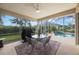 Outdoor patio with a round table set, a grill, and views of the pool and surrounding garden at 7615 Charleston St, Bradenton, FL 34201