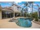 A beautiful screened in pool with a custom design surrounded by lush landscaping and elegant furniture at 7615 Charleston St, Bradenton, FL 34201