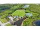 Aerial view of a playground, tennis court, and lush green field near a pond at 7615 Charleston St, Bradenton, FL 34201