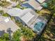 Aerial view featuring a screened pool, landscaped yard, and solar panels highlighting the home's outdoor living and energy efficiency at 7716 Geneva Ln, Sarasota, FL 34243