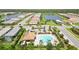 Aerial view of the community pool and clubhouse with palm trees, lounge chairs, and ample parking at 7758 Summerland Cv, Bradenton, FL 34202