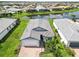 Beautiful aerial view of a home with a brick driveway, lush landscaping, and a well-maintained front lawn at 7758 Summerland Cv, Bradenton, FL 34202