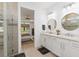 Bright bathroom features double sink vanity, modern lighting and a glass door shower with decorative tile detail at 7758 Summerland Cv, Bradenton, FL 34202