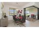 Dining room with a glass table, modern chairs, contemporary chandelier, and sliding glass doors to the patio at 7758 Summerland Cv, Bradenton, FL 34202