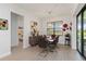 Elegant dining room with a glass table, stylish chairs, modern chandelier, and view of the bedroom at 7758 Summerland Cv, Bradenton, FL 34202