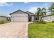 Charming single-Gathering home with a brick driveway, manicured lawn, and tropical landscaping at 7758 Summerland Cv, Bradenton, FL 34202