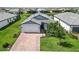 Charming single-Gathering home with lush landscaping, a brick driveway, and a well-maintained front lawn at 7758 Summerland Cv, Bradenton, FL 34202