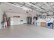 Organized garage showcasing epoxy flooring, a refrigerator, storage cabinets, and bicycle storage at 7758 Summerland Cv, Bradenton, FL 34202
