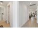 Bright hallway with wood floors leading to the dining room and kitchen at 7758 Summerland Cv, Bradenton, FL 34202