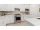 Modern kitchen featuring stainless steel appliances, white cabinetry, and a stylish subway tile backsplash at 7758 Summerland Cv, Bradenton, FL 34202
