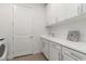 Clean laundry room with a sink, cabinets, white appliances, and a modern design at 7758 Summerland Cv, Bradenton, FL 34202