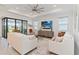 Spacious living room featuring a large sliding glass door and a tray ceiling with modern ceiling fan at 7758 Summerland Cv, Bradenton, FL 34202