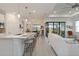 Open-concept kitchen, dining, and living area with large sliding glass doors and a neutral color palette at 7758 Summerland Cv, Bradenton, FL 34202