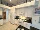 Bright kitchen features white cabinetry, modern appliances, and a view into another room at 8616 15Th Nw Ave, Bradenton, FL 34209