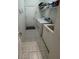 Laundry room with washer, dryer, utility sink, storage shelves, and tiled floor at 8616 15Th Nw Ave, Bradenton, FL 34209