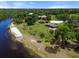 Aerial view of a stunning waterfront property with a sandy beach and a charming covered pavilion at 918 Fernleaf Run, Bradenton, FL 34212