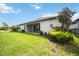 View of the spacious backyard with a covered patio, lush landscaping, and a well-maintained lawn at 918 Fernleaf Run, Bradenton, FL 34212
