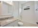 Well-lit bathroom with granite countertop, white tiled shower-tub combination, and modern fixtures at 918 Fernleaf Run, Bradenton, FL 34212
