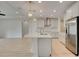 Modern kitchen with a center island, stainless steel appliances, and sleek white cabinetry at 918 Fernleaf Run, Bradenton, FL 34212