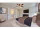 This main bedroom features an en-suite bath, a ceiling fan, a sitting area and neutral decor at 918 Fernleaf Run, Bradenton, FL 34212