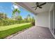 Covered brick patio with view of green backyard and landscaping at 918 Fernleaf Run, Bradenton, FL 34212
