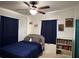 Bright bedroom with ceiling fan, a full bed, a bookshelf, and art at 1224 38Th W St, Bradenton, FL 34205