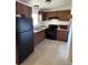 Functional kitchen with brown cabinets, modern black appliances, and efficient corner layout at 1224 38Th W St, Bradenton, FL 34205