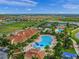 An aerial view of the IslandWalk community reveals the pool, tennis courts, clubhouse, and neighborhood layout at 13391 Dimarco St, Venice, FL 34293