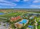Aerial view of community with clubhouse, pool, tennis courts, and ponds at 13391 Dimarco St, Venice, FL 34293