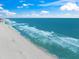 Beautiful aerial view of a white sand beach with waves crashing on the shore on a bright sunny day at 13391 Dimarco St, Venice, FL 34293
