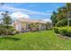 Beautifully landscaped front lawn with healthy green grass, vibrant plants, and a well-maintained exterior in a sunny environment at 13391 Dimarco St, Venice, FL 34293